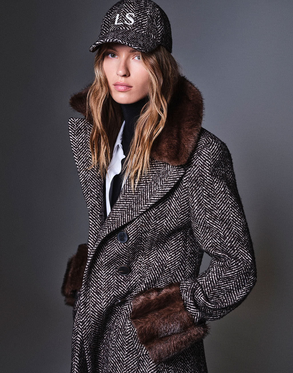 Luisa Spagnoli, campagna Autunno/Inverno 2026: cappotto spigato con collo in pelliccia ecologica e cappellino LS